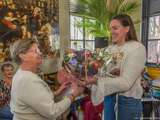 Vrouw overhandigt boeket bij de uitreiking van de Pelikaan.
