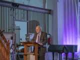 Man spreekt op podium in Nicolaikerk bij aftrap 80 jaar vrijheid.