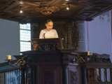 Meisje op podium met microfoon in Nicolaikerk bij aftrap 80 jaar vrijheid.