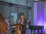 Man spreekt op podium in Nicolaikerk bij aftrap 80 jaar vrijheid.