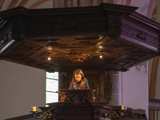 Meisje op podium met microfoon in Nicolaikerk bij aftrap 80 jaar vrijheid.