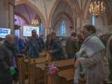 Groep mensen in de Nicolaikerk voor de aftrap van 80 jaar vrijheid.