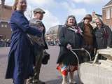 Verklede mensen glimlachen op kerkplein bij Living History Appingedam.