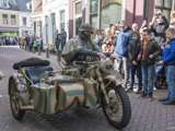 Verklede soldaat rijdt op oude oorlogsmotor bij Living History Appingedam.