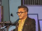 Man op podium in Nicolaikerk bij aftrap 80 jaar vrijheid.