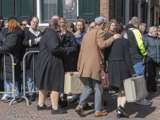 Verklede mensen met koffers op kerkplein bij Living History Appingedam.