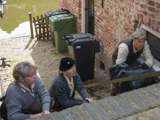 Verklede mensen duiken onder bij trap bij Living History Appingedam.